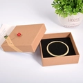 Golden pearl bracelet inside a kraft paper jewelry box with a small red flower decoration - 12x12x4cm