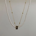 Detail of double-layer necklace with white pearls and a black crystal cylindrical pendant - Double Layer Pearl Black Zirconia Ball Necklace