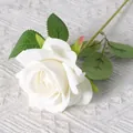 Single white artificial silk rose with green leaves on a textured white background - Elsa White