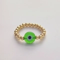 Macro-opname van 18K vergulde kralenring met groene glazen evil eye bedel als ornament - Maat 7 (Elastisch) / Groen