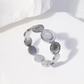 Minimalistischer Edelstahlring in Silber mit Sonnenstrahlmuster auf hellem Grund - Stahlfarbe