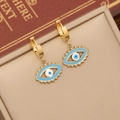 Gold evil eye hoop earrings with blue enamel charms displayed in a premium jewelry box - Evil Eye Earrings