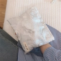 Dettaglio del tessuto jacquard a rose in filo dorato su una piccola trousse bianca - Argento