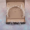 Primer plano de conjunto nupcial con perlas blancas y cristales en caja de regalo - Diadema con Pendientes de Botón
