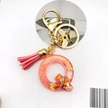 Detail of pink resin letter Q keychain with glitter, leather tassel and gold bee charm - Letter Q Bee Keychain