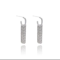 Dettaglio di orecchini a nappa argentati con lunghe catene di metallo su sfondo bianco - R1085 Lettera G d'argento