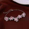 Dettaglio del braccialetto in argento con pietre di zircone rosa su seta marrone - Bracciale a fiori in zirconia rosa