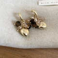 Gros plan de boucles d'oreilles cœur doré avec perles œil de tigre sur bois - Boucles d'Oreilles Pendantes Coeur à Franges Café Doré avec Tige en Argent (HE29539)