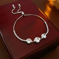 Macro detail of silver adjustable bracelet with oval zircons on red wooden box - Slider Bracelet / Silver