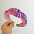 Detail of a multi-color striped knotted headband with glossy fabric and padded structure - Knot Headband / Rose Red