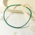 Detail of emerald green beaded necklace with gold clasp on white ceramic tray - Emerald Green/Gold