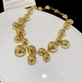 Vista macro di una collana dorata con grandi sfere metalliche dalla finitura a specchio - Collana - Oro