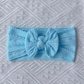 Detail of light blue cable knit baby headband with a large decorative soft bow - Blue