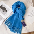 Classic blue 100% wool scarf with twisted tassels displayed on a white marble surface - Peacock Blue