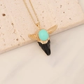 Detail view of a bull head pendant with turquoise stone on beige stone texture - Turquoise and Black Bull Skull (12#)
