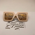 Detail of beige square sunglasses with chunky gold chain temples on a light background - Beige Pink Frame Tea Lens