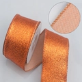 Orange glittering Christmas ribbon with reinforced stitched edges on a white spool roll - Other processes