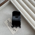 Close-up of black 5cm mini hair claw clip inside a beige lined wooden jewelry box - Bright Black