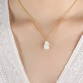 Elegante gouden titanium ketting met witte schelp konijn hanger gedragen door model - 40+5cm / Goud