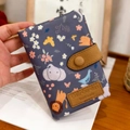 Short tri-fold wallet with blue animal patterns and a brown snap-button leather strap - Handheld Navy Animal Paradise