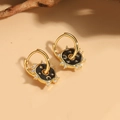 Macro detail of gold hoop earrings with black enamel sun and moon celestial charms - Moon & Star