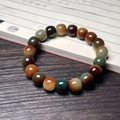 Detailed view of polished multi-colored agate beads on a vintage wooden desk with calligraphy - Dunhuang Old Type Single Loop Style