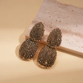 Detalle macro de pendientes colgantes dorados vintage con cuentas de ámbar facetadas - Pendientes de Botón-Oro Antiguo