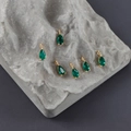 Macro detail of six emerald green teardrop pendants with 18k gold plated zircon setting - Green Water Drop Style (M108903)