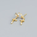 Orecchini a foglia dorati con zirconi brillanti su uno sfondo grigio chiaro - Argento 925 / Oro