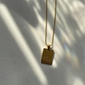 Detail of 18K gold plated square pendant with The World Is Yours engraving on bead chain - THE WORLD IS YOURS / Gold