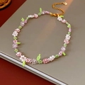 Detail der bunten Blumenperlenkette mit goldenem Herzanhänger und Karabinerverschluss - Halskette + Armband Set - Rosa