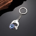 Detail eines Delfin-Schlüsselanhängers mit blauer Evil Eye Perle und polierter Legierung - Delfin