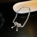 Detail of silver bow necklace with sparkling crystals and elegant teardrop pendants - Silver Bow Necklace