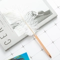 Elegant white feather ballpoint pen with a slim rose gold metal barrel on a magazine - Rose Gold (White Feather)