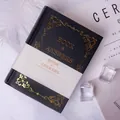 Mini bilingual Book of Answers in black hardcover with elegant gold foil pattern - Black