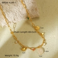 Detailed shot of golden link necklace with heart, pearl, and natural stone charms on stone - 18K Gold / Multi-Element Heart Pearl Chain (NMSN-A349-1)