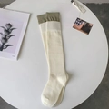 Cream knit knee-high socks with olive green ribbed cuffs on an aesthetic background - Green Cuff