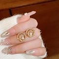 Detailed view of gold pearl earrings with pave crystals held by hand against a sweater - 19# Silver Needle - Gold Pearl Cluster