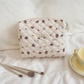 Détail d'une trousse à maquillage matelassée avec motif chien et pinceaux de maquillage - Petit Chien Pain