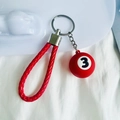 Dettaglio di un portachiavi con mini palla da biliardo rossa n. 3 e cinturino in pelle PU - N.3 (Rosso)