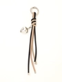 Dettaglio del portachiavi in pelle intrecciata con cuore d'argento e nappine chic - Nero e Beige