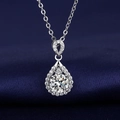 Macro detail of teardrop pendant with round-cut center stone on dark blue velvet - Xl-46 [with Cross Chain]