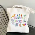 White canvas tote bag featuring colorful Science Rocks graphics on a black chair - C17 Science Rocks No Inner Pocket No Zipper