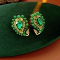 Vista macro di orecchini vintage in oro con pietre preziose verde smeraldo su velluto - Orecchini Singoli - Perno in Argento 925 - Verde