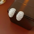 Macro shot of silver pavé hoop earrings with zircon spiral texture on leather box - Silver (Silver Pin) / Silver