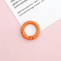 Detail shot of a bright orange 20mm round spring gate ring hook on a pink background - Orange