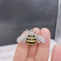 Cute honey bee brooch with yellow enamel belly and sparkling zircon wings on a hand - Style 19