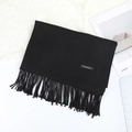 Écharpe à franges noire en imitation cachemire pliée sur une table blanche épurée - 70×200cm / Noir