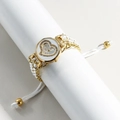 Detailed macro view of heart-patterned watch dial with white braided wristband - Gold Case White Dial