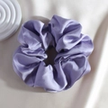 Detail of purple satin scrunchie with a soft silk texture and elegant glossy finish - Purple